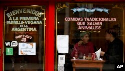 People eat at "La Reverde" vegan restaurant in Buenos Aires, Argentina, Friday, Aug. 30, 2019. At Buenos Aires' first vegan grill, the house specialty resembles the country's bife de chorizo, a popular cut of boneless beef cooked on a grill. (AP Photo/Natacha Pisa