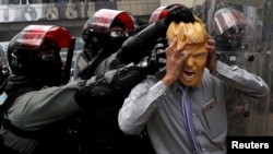 Seorang pedemo mengenakan topeng Presiden AS Donald Trump bentrok dengan polisi saat demonstrasi di distrik Causeway Bay, Hong Kong, China, 29 September 2019.