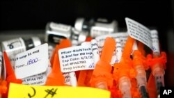 FILE - Syringes filled with Pfizer COVID-19 vaccines sit at the ready at a vaccination clinic at PeaceHealth St. Joseph Medical Center in Bellingham, Wash., June 3, 2021.