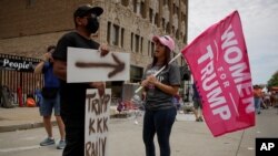 People argue outside the BOK Center where President Trump will hold a campaign rally in Tulsa, Okla., Saturday, June 20, 2020. (AP Photo/Charlie Riedel)