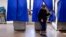 FILE - A voter leaves a polling booth during the U.S. presidential election in Philadelphia, Pennsylvania, Nov. 8, 2016. Most units lack paper records needed to check for fraud and errors, according to a report released Tuesday.