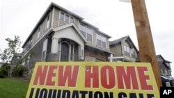 New home liquidation sign is seen in front of a home in Happy Valley, Oregon