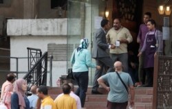 People wait outside a bakery and pastry shop named "The Baker" and known as "El Khabaz," for traditional Eid al-Fitr festivities sweets and biscuits, amid concerns over the coronavirus disease, in the Cairo suburb of Maadi, Egypt, May 21, 2020.