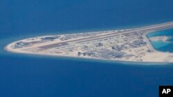 Chinese structures and an airstrip on the man-made Subi Reef at the Spratly group of islands in the South China Sea are seen from a Philippine Air Force C-130 transport plane of the Philippine Air Force, April 21, 2017. The South China Sea issue is expect