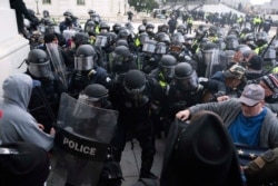 FILE - U.S. Capitol Police push back rioters trying to enter the Capitol in Washington, Jan. 6, 2021.