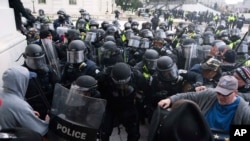 Arhiva - Policija Kapitola SAD pokušava da potisne demonostrante i spreči ih da uđu u sedište Kongresa, u Vašingtonu, 6. januara 2021.