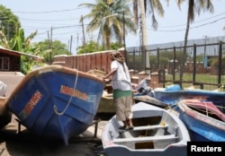 A fisherman checks a boat that was pulled from the water ahead of the arrival of Hurricane Beryl, in Port Royal, Jamaica, on July 2, 2024.