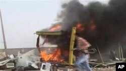 In this image taken from Associated Press Television News footage an unidentified person runs away from a shelled checkpoint near the port area of Misrata, Libya, May 1, 2011