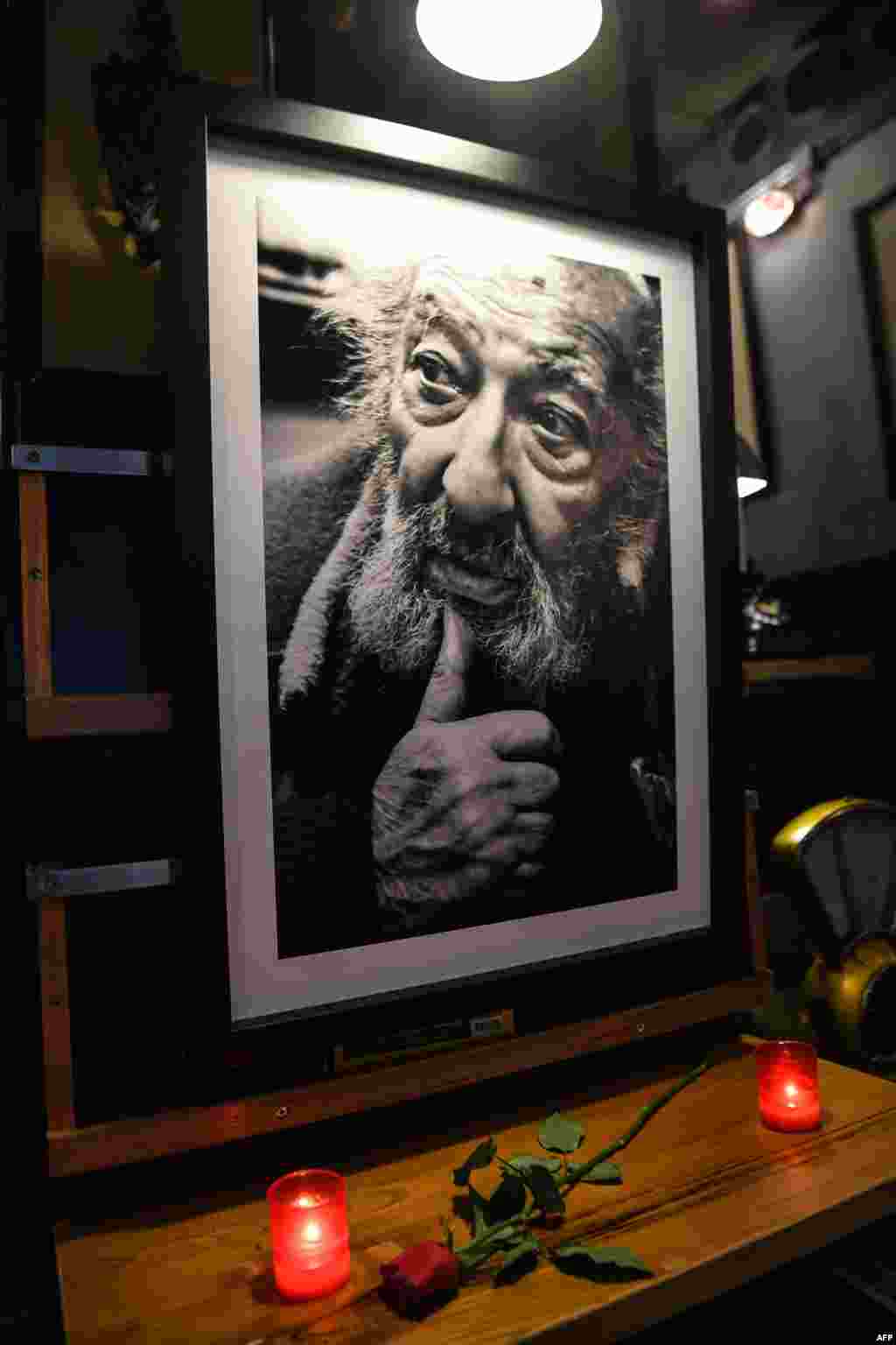 Candles and a rose are put next to an image of late Turkish photographer Ara Guler at Ara Cafe in Istanbul. The photographer, famed for his images of Istanbul that captured almost 75 years of the city&#39;s history, died this week at the age of 90.