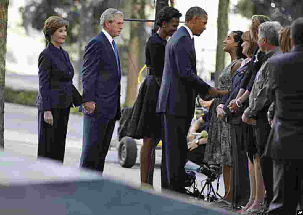 US President Barack Obama speaks with victims' relatives as he visits the north pool of the World Trade Center site with first lady Michelle Obama, former President George W. Bush and former first lady Laura Bush (L) during ceremonies marking the 10th ann
