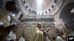 Latin Patriarch of Jerusalem Pierbattista Pizzaballa, center, walks with Christian clergymen holding candles during the Easter Sunday procession at the Church of the Holy Sepulchre in Jerusalem, April 16, 2017. 