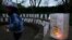 FILE - A volunteer helps setup lights in paper bags decorated with messages for the deceased during an Out of the Darkness Walk event organized by the Cincinnati Chapter of the American Foundation for Suicide Prevention in Sawyer Point park, Oct. 15, 2017, in Cincinnati.