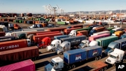 FILE: Trucks line up to enter a Port of Oakland shipping terminal in Oakland, Calif on 11.10.2021. The U.S. GDP declined slightly in 2022's second quarter, the second slip in a row. 