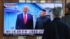 Orang-orang menonton siaran berita TV yang menampilkan gambar Pemimpin Korea Utara Kim Jong Un dan Presiden AS Donald Trump (kiri), di Stasiun Kereta Seoul, 31 Desember 2019.