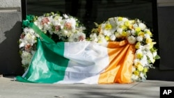 An Irish flag is draped over wreaths at the Library Gardens apartment complex in Berkeley, Calif., where six young people died in a balcony collapse, June 16, 2015.