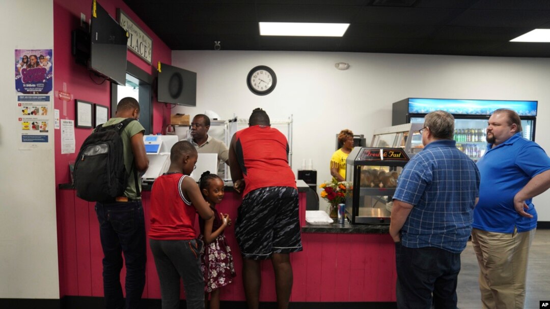 Romane Pierre of Rose Goute Creole Restaurant in Springfield, Ohio, helps a line of customers, Sept. 16, 2024. 