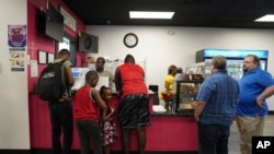 Romane Pierre of Rose Goute Creole Restaurant in Springfield, Ohio, helps a line of customers, Sept. 16, 2024.