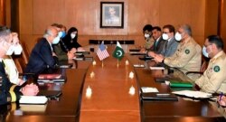 In this photo released by Pakistan's military, a U.S. delegation headed by peace envoy for Afghanistan, Zalmay Khalilzad, third left, hold talks with Pakistan's army chief, Gen. Qamar Javed Bajwa, second right, in Rawalpindi, Sept. 14, 2020.