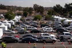 Motorists line up for their COVID-19 vaccine a joint state and federal mass vaccination site set up on the campus of California State University of Los Angeles in Los Angeles, Feb. 16, 2021.