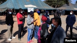 FILE - People queue to be vaccinated against COVID-19 at a clinic in Harare, Zimbabwe.
