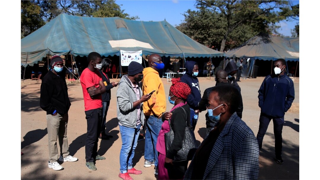 FILE - People queue to be vaccinated against COVID-19 at a clinic in Harare, Zimbabwe, July 8, 2021.