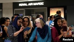 Teman-teman dan kerabat menunggu para penumpang penerbangan internasional tiba di Amerika di Bandara Internasional Washington Dulles di Dulles, Virginia, 14 Juli 2017.