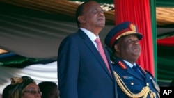 Kenyan president Uhuru Kenyatta, centre, Commander-in-Chief of the Armed Forces, left, stands with Gen Julius Waweru Karangi, right, Chief of the Defence Forces, as they watch the passing out parade and fly over by the Kenyan Air Force, Oct. 20, 2013.