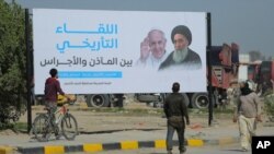 iraquíes caminan junto a un cartel que anuncia la visita del papa Francisco y su reunión planificada con el prominente líder musulmán chiíta, el ayatolá Ali al-Sistani , en Najaf, Irak, 3 de marzo de 2021.