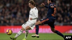 Gelandang Valencia Daniel Parejo beradu dengan Gelandang Real Madrid asal Kroasia, Luka Modric (L), dalam laga Liga Spanyol antara Real Madrid vs Valencia di Stadion Santiago Bernabeu di Madrid, 1 Desember 2018.
