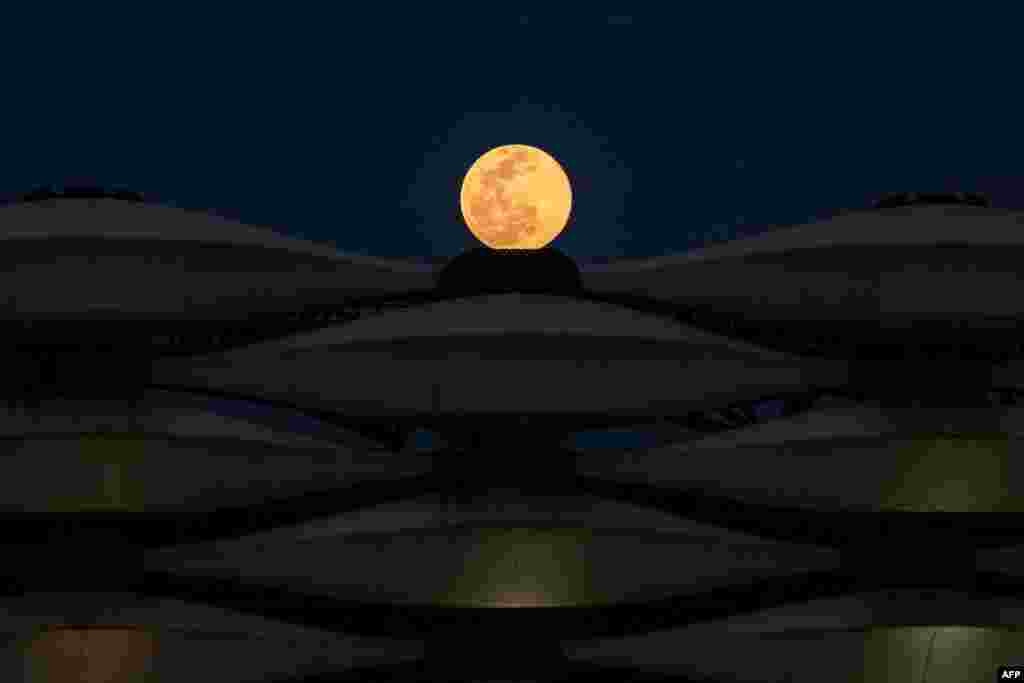A view of the rising full &amp;quot;Worm Moon&amp;quot; above Basra International Stadium in the southern Iraqi city, March 28, 2021.