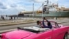 Un hombre toma fotografías del submarino de propulsión nuclear Kazan (izq.) y del remolcador fragata Almirante Gorshkov (der.), parte del destacamento naval ruso que visita Cuba, después de su llegada al puerto de La Habana el 12 de junio de 2024. 