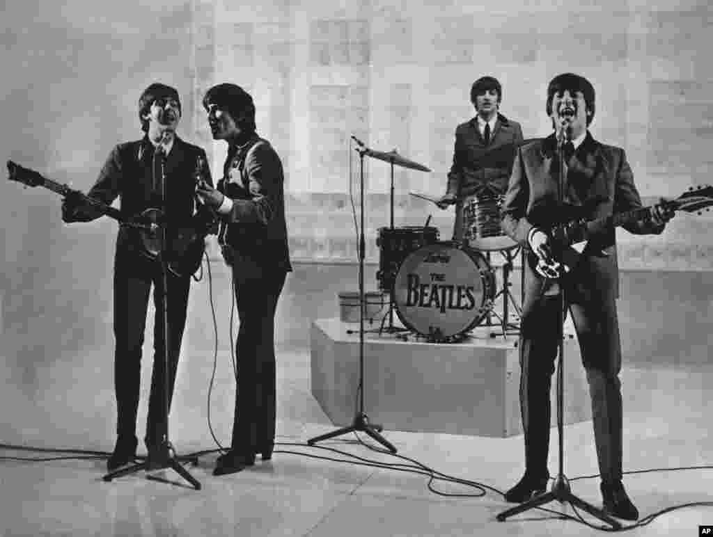 The Beatles are seen performing, date unknown. From left to right: Paul McCartney, George Harrison, Ringo Starr, and John Lennon. 