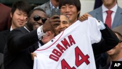 Pemain Red Sox Boston David "Big Papi" Ortiz mengambil foto "selfie" bersama Presiden Barack Obama yang memegang seragam khusus untuknya. 