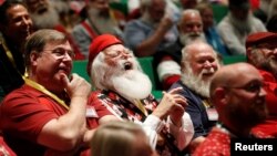 Para Santa tertawa saat belajar semangat Santa di sekolah Santa Charles W. Howard di Midland, Michigan.