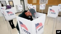 FILE - Chris Helps of Earlham, Iowa, fills out his ballot during early voting in Adel, Iowa, Oct. 20, 2020.