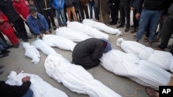 FILE — Palestinians mourn their relatives from the Al Kahwaji family killed in the Israeli bombing of the Gaza Strip in Deir al Balah on February 12, 2024. 