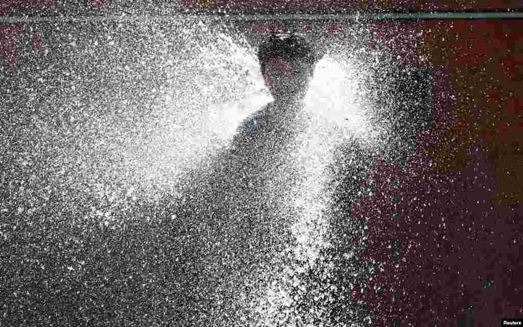 A boy cools off in a fountain during hot weather in central Brussels, Belgium June 24, 2020. REUTERS/Francois Lenoir TPX IMAGES OF THE DAY