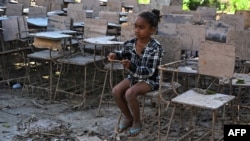 Una niña sentada en una silla escolar destruida tras el paso de los huracanes Eta e Iota en 2020, en el municipio de La Lima, Honduras, el 8 de enero de 2021.
