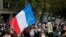 People gather at the Place de la Republique in Paris, to pay tribute to Samuel Paty, the French teacher who was beheaded on the streets of the Paris suburb of Conflans-Sainte-Honorine, Oct. 18, 2020. 