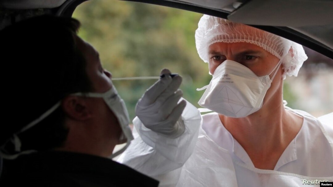 Un trabajador de la salud realiza una prueba del coronavirus en un puesto de auto-servicio en Laval, Francia.
