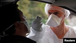 Un trabajador de la salud realiza una prueba del coronavirus en un punto móvil en Laval, Francia.