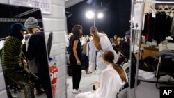 FILE - In this March 8 2015 file photo, models wait backstage during the Paris Fashion Week in Paris. Two of France's biggest luxury companies LVMH and Kering have joined forces to ban size zero models. (AP Photo/Zacharie Scheurer)