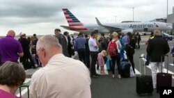 Dalam gambar ini diambil dari video ini, para penumpang berdiri di aspal landasan pacu bandara Manchester, Inggris, setelah dievakuasi, Rabu 5 Juli 2017. Pihak berwenang tengah memeriksa tas sebuah yang mencurigakan di Terminal 3 bandara tersebut.