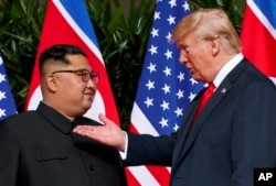 Presiden AS Donald Trump, kanan, bertemu dengan pemimpin Korea Utara Kim Jong Un di Pulau Sentosa di Singapura, 12 Juni 2018. (Foto: AP)