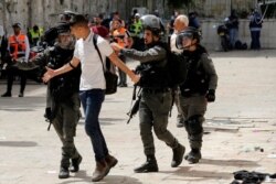 Policías israelíes detienen a un joven palestino durante choques en los alrededores de la mezquita de al-Aqsa en Jerusalén el 10 de mayo de 2021.