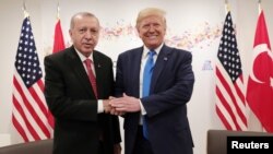 Presiden Turki Recep Tayyip Erdogan berjabat tangan dengan Presiden AS Donald Trump dalam pertemuan di sela KTT G20 di Osaka, Jepang 29 Juni 2019.