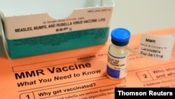 FILE - A vial of measles, mumps and rubella vaccine and an information sheet is seen at Boston Children's Hospital in Boston.