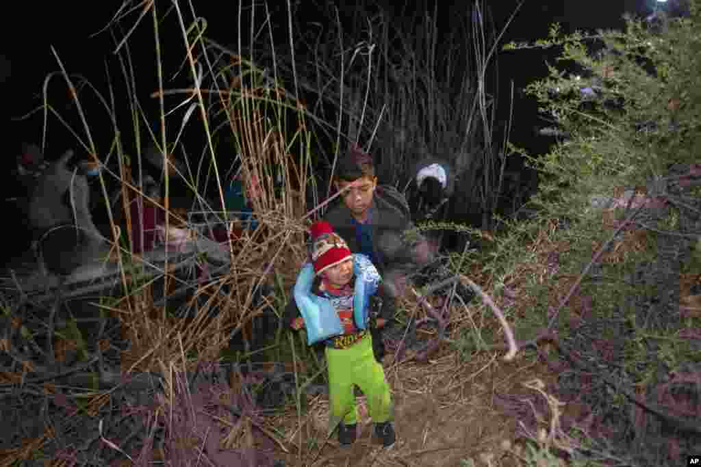 A child weeps as he is unloaded from an inflatable raft after being smuggled into the United States by crossing the Rio Grande River in Roma, Texas, March 28, 2021.