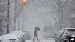 A man crosses the street through heavy snow in Hoboken, New Jersey, March 7, 2018. 