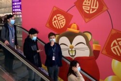 People wear face masks as they ride an escalator at the Hong Kong International Airport in Hong Kong, Jan. 21, 2020.